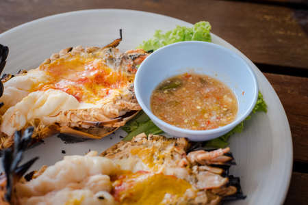 A giant river prawn is a Thai food recipe eat with Spicy sauce made from fish sauce, chilli, garlic mix together.の写真素材