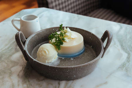 Dessert is white pudding with vanilla ice cream.の写真素材