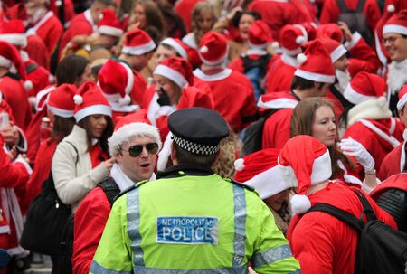 Annual Group crowd of santas in London with policemanのeditorial素材