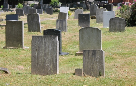 Tombstone and graves in an ancient church graveyard の写真素材