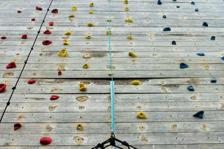 wooden climbing wall with bright colored foot holdsの写真素材