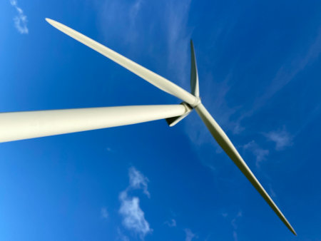 Wind farm turbines that produce electricity energy. Windmill Wind power technology productions Wind turbines standing in green field - stock photoの写真素材