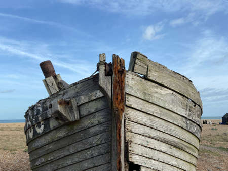 A closeup shot of an old wooden boat on the beach under a blue skyの写真素材