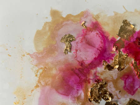 Abstract background of pink and gold watercolor stains on a white paperの写真素材