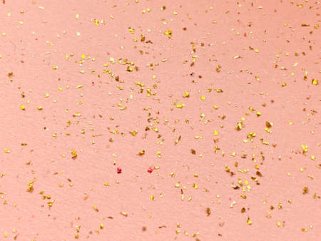 Gold glitter on a pink background. Festive background for your design.の写真素材