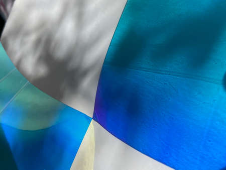 Blue and white abstract background with shadow of a tree on the wall