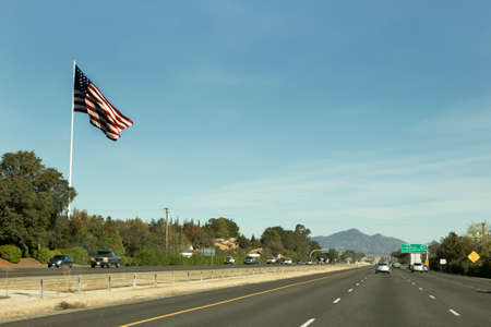 A large US flag waves at passers- by on interstate 5 near Anderson, California.の写真素材