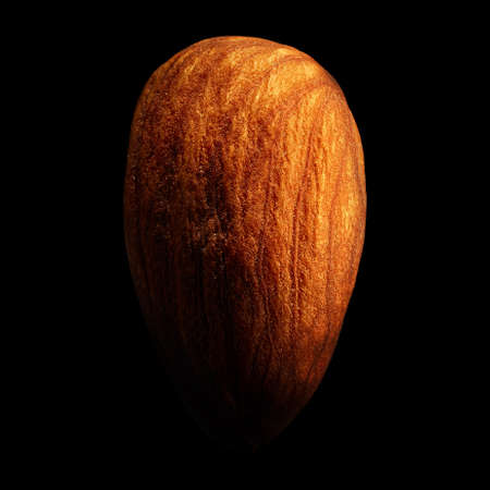 Almond isolated on black background with reflection. Close-up or macro. Health conceptの写真素材