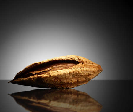 Almond on black background with reflection. Close-up or macro. Health concept