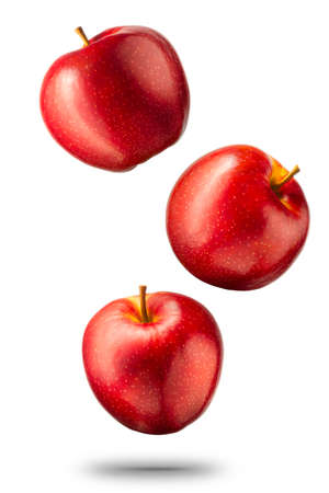 Falling red apples isolated on white background  and shiny reflectionsの写真素材