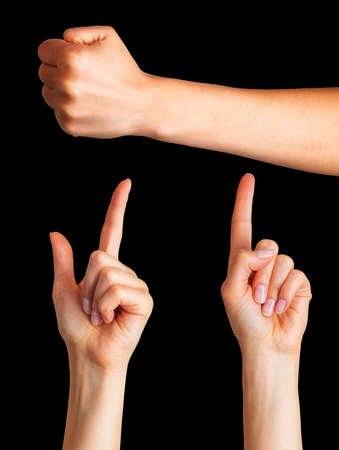 Set of woman hands with the index finger pointing up and fist on black background. Isolated with clipping path.の写真素材
