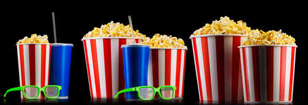 Set of striped buckets with popcorn, cups of drink and glasses isolated on black background, movie night concepto or watching TV.の写真素材