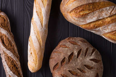 Top view photo of fresh baked bread on painted black wooden table.