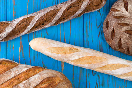 Top view photo of fresh baked bread on painted blue wooden table.の写真素材