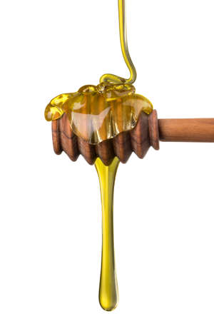 Honey on a wooden dipper isolated on white background with clipping path. Bee products by organic natural ingredients conceptの写真素材