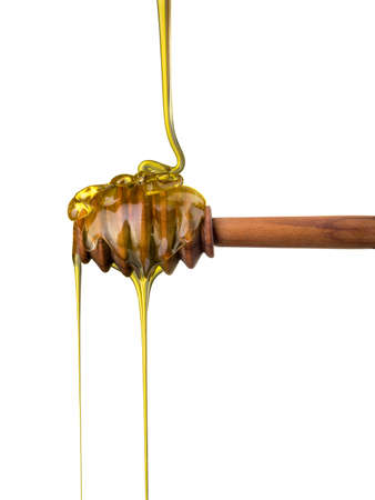 Honey on a wooden dipper isolated on white background with clipping path. Bee products by organic natural ingredients conceptの写真素材