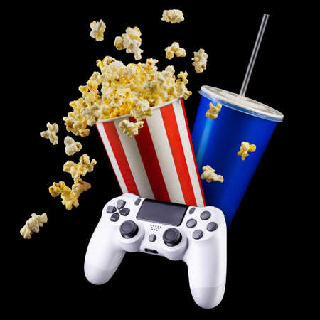 Flying popcorn and video game joystick gamepad isolated on a black background