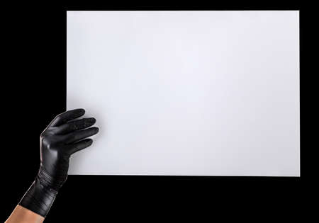Hand in black gloves showing or holding blank cardboard isolated on blackの写真素材