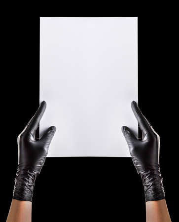Hand in black gloves showing or holding blank cardboard isolated on black background. Isolated with clipping path.の写真素材