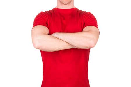 Front view of confident male in blank red t-shirt posing with crossed arms isolated white background...