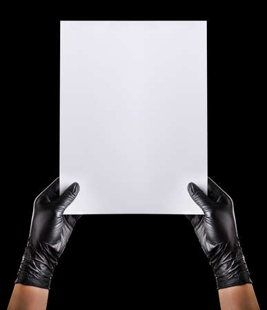 Hand in black gloves showing or holding blank cardboard isolated on black background. Isolated with clipping path.の写真素材