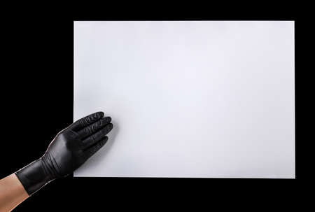 Hand in black gloves showing or holding blank cardboard isolated on black background. Isolated with...