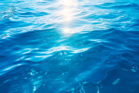 Underwater view of blue surface of ocean or sea. Abstract waves underwater and rays of sunlight shining through.の素材