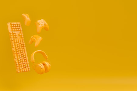 Neatly organized home office setup with tech gadgets like a wireless keyboard, mouse, gaming controllers and headphones on monochrome backgroundの写真素材