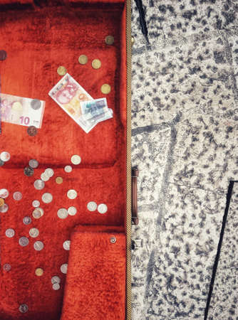 Detail of a musician suitcase on the street with money