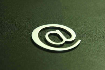 Silver 3D email sign against a black backgroundの写真素材