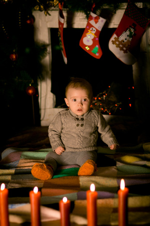 baby sitting on  floor near fireplace on Christmas Eveの写真素材