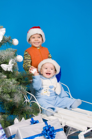 happy brothers in Santa Claus hats near Christmas treeの写真素材