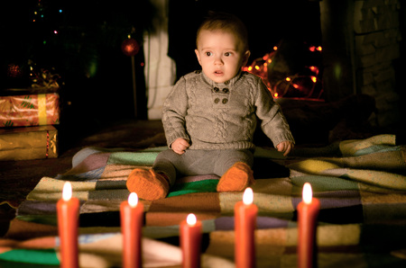 baby sitting on  floor near fireplace on Christmas Eveの写真素材