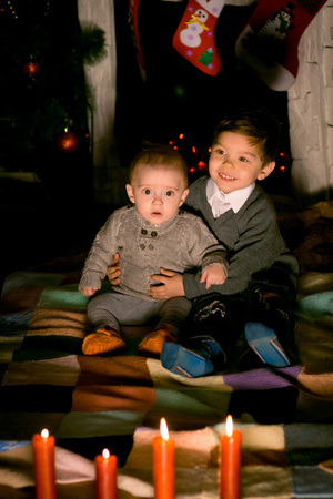 baby sitting on  floor near fireplace on Christmas Eveの写真素材