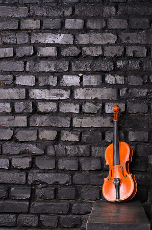 violin on background dark brick wall for text musicの写真素材