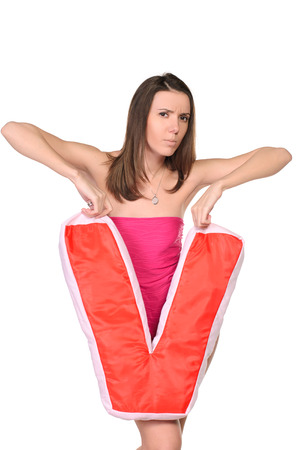 sensual girl in  pink suit and soft toy in hands of letter V on white studio backgroundの写真素材