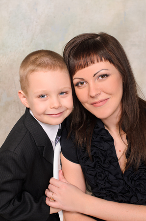 Mother and son gently holding hands and smilingの写真素材