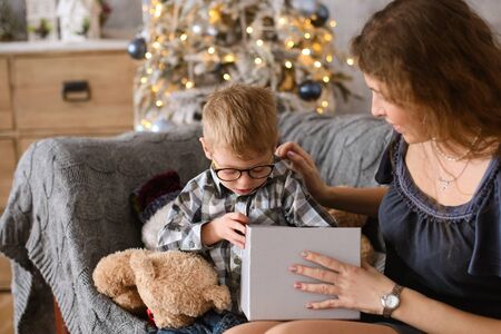 boy was delighted and surprised at gift he saw in big gray box, in his mother's hands,の写真素材