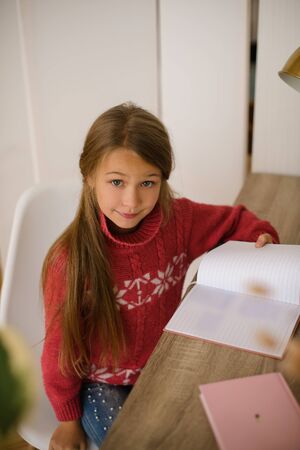 girl doing homework at desk. Occupation at home during quarantine, self-studyの写真素材
