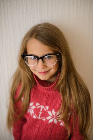 portrait of beautiful girl of school age with glasses in red sweater