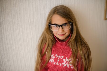 portrait of beautiful girl of school age with glasses in red sweater