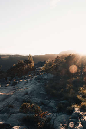 Sunset in the mountains. Rocks and trees in the foreground.の写真素材