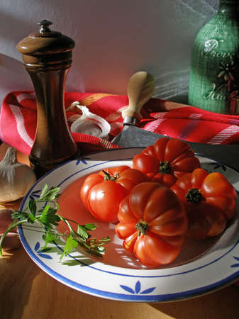 Tomatoes, pepper mill andolive oil in the kitchen in the sunset lightの写真素材