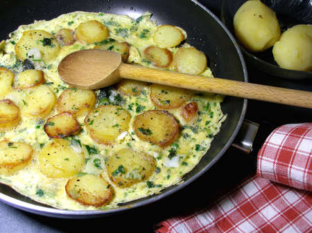 Omelet with potatoes and chopped herbsの写真素材