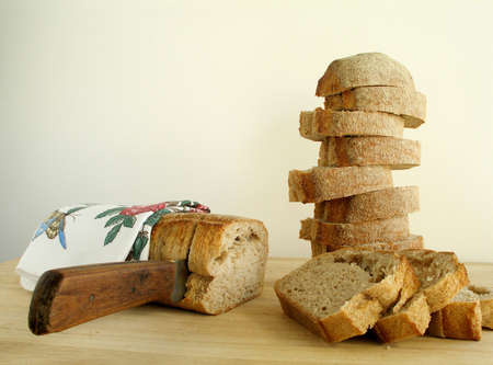 Bread being cut and pilled up on the cutting boardの写真素材