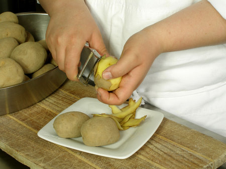Chef is peeling potatoesの写真素材