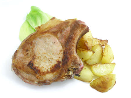 Pork cutlet with potatoes served on a white tray with a salad leafの写真素材