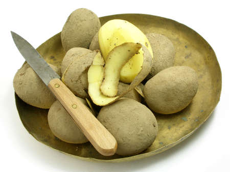 Peeling potatoes with an old fashion knifeの写真素材