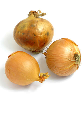 Three onions arranged on a tableの写真素材