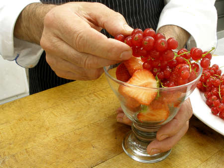 preparing a glass of red fruits for dessertの写真素材